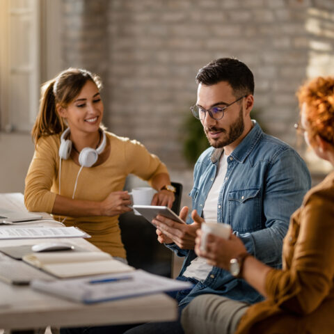 Young businessman using touchpad while having a meeting with fem